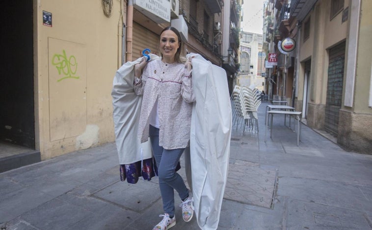 Imagen principal - Inma Garcerá, fallera mayor de Linterna-Na Robella, descargando la indumentaria antes de acceder al piso. 