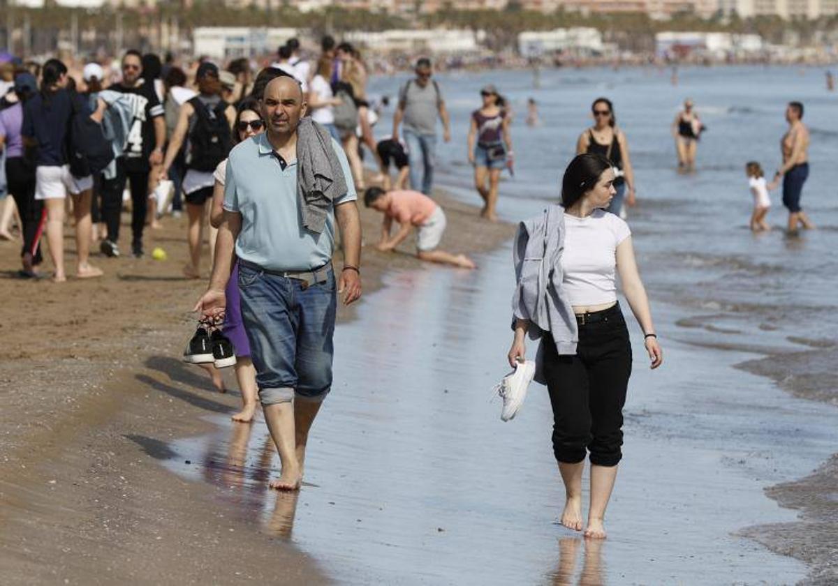 Personas pasean en la playa de la Malvarrosa.