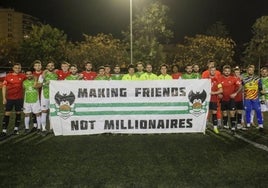 Los jugadores posando con una pancarta que pone 'Haciendo amigos. No millonarios'.