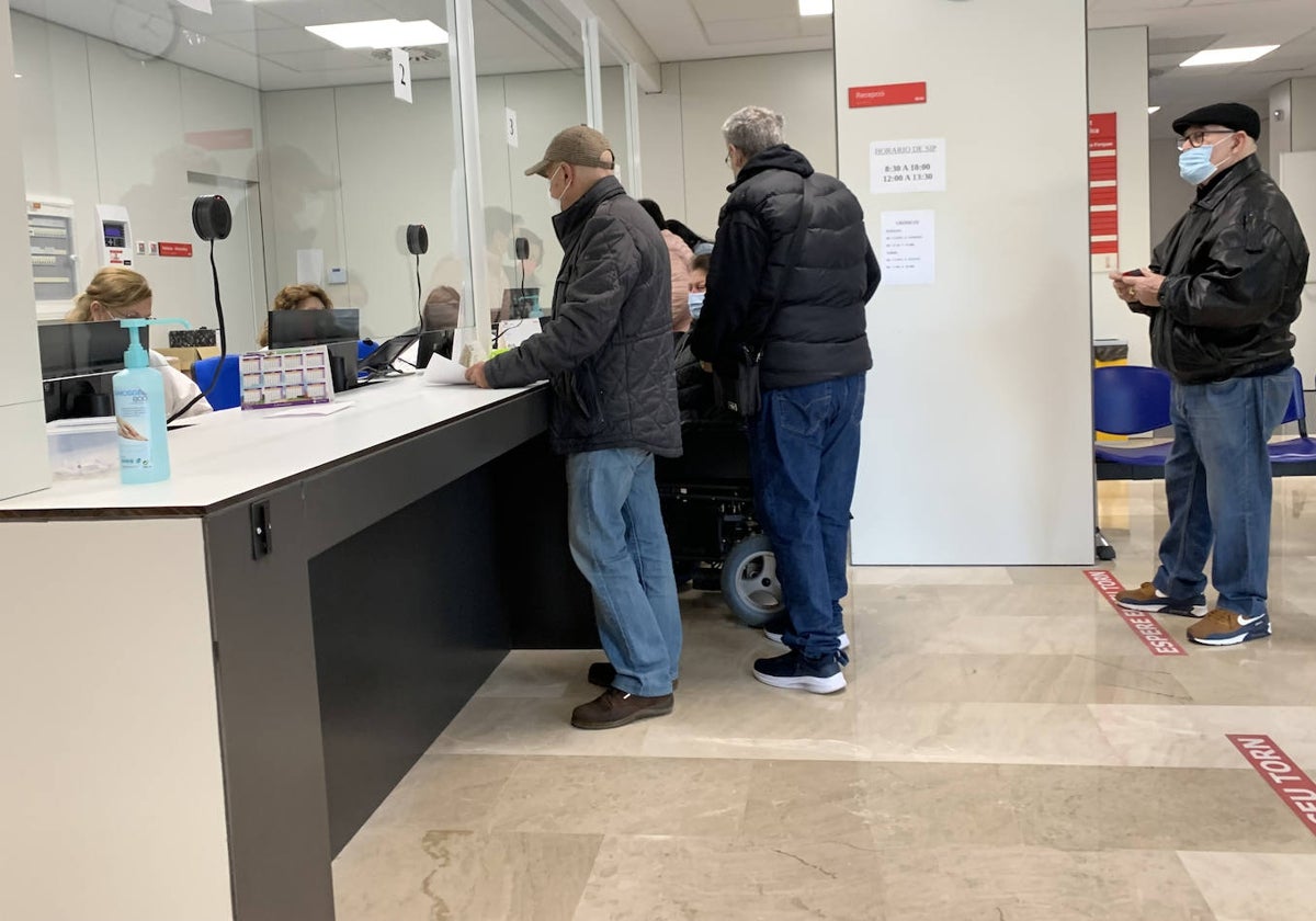 Pacientes esperan su turno frente al mostrador de un centro de salud valenciano.