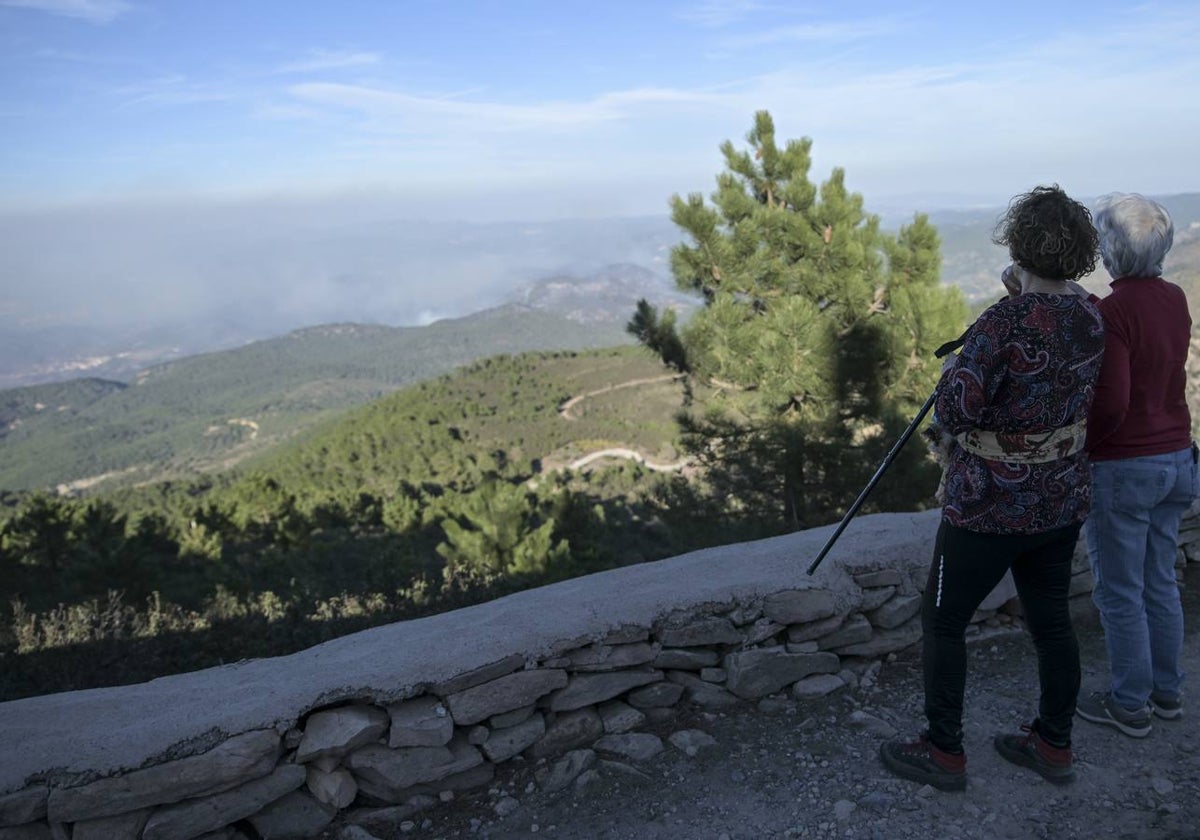 Dos personas observan el humo del incendio.