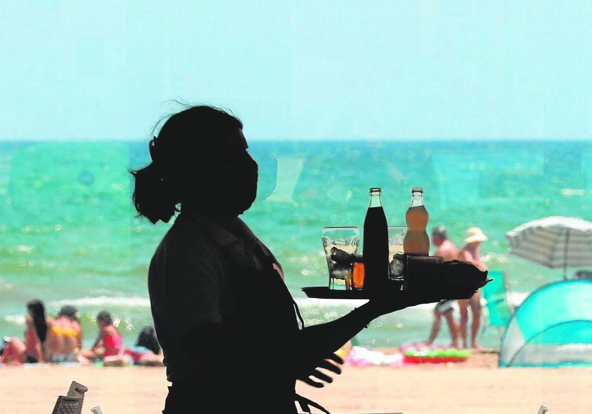 Una camarera, en plena jornada laboral en una terraza a pie de playa.