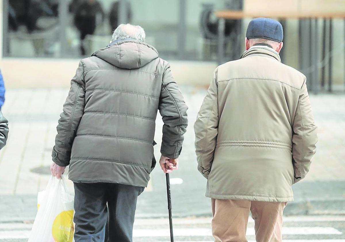 Dos jubilados pasean por la calle.