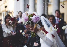 Unos novios, a la salida de la ceremonia nupcial.