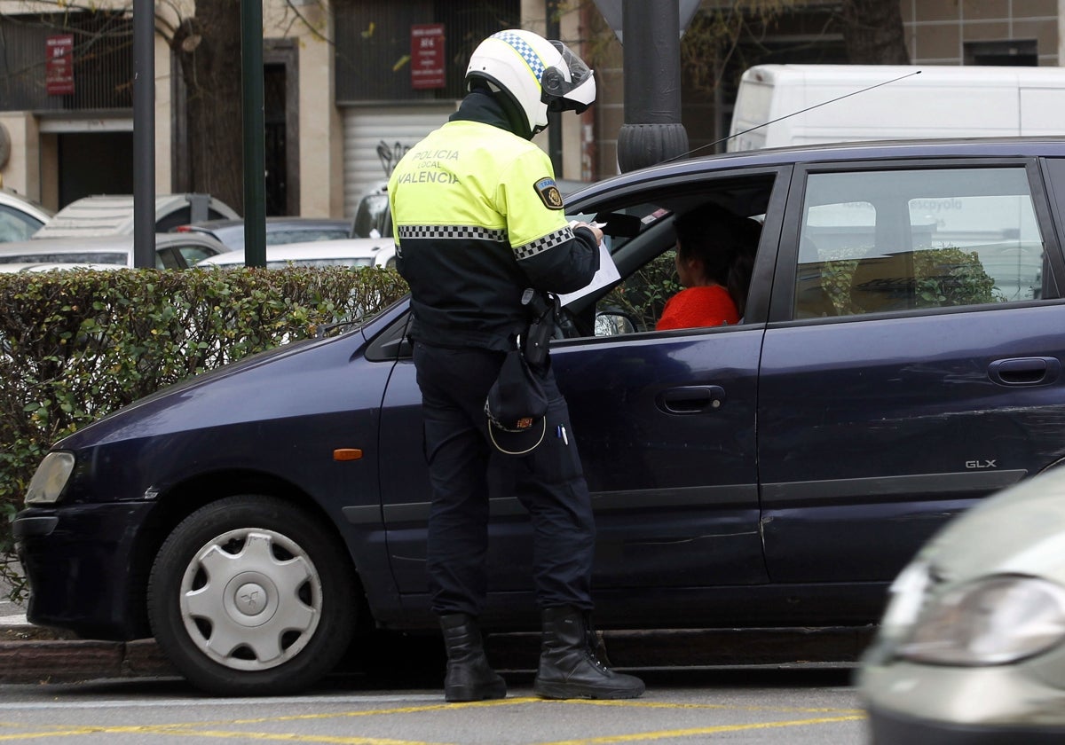 Un policía local impone una multa a una conductora.