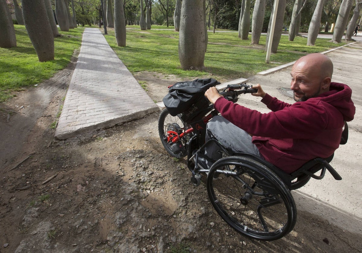 Alfredo Basconcillos, vocal de Aspaym CV, muestra una de las barreras del carril bici del jardín del Turia, a la altura del puente del Real.