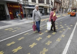 Dos viandantes cruzan por la supermanzana de la Pechina.