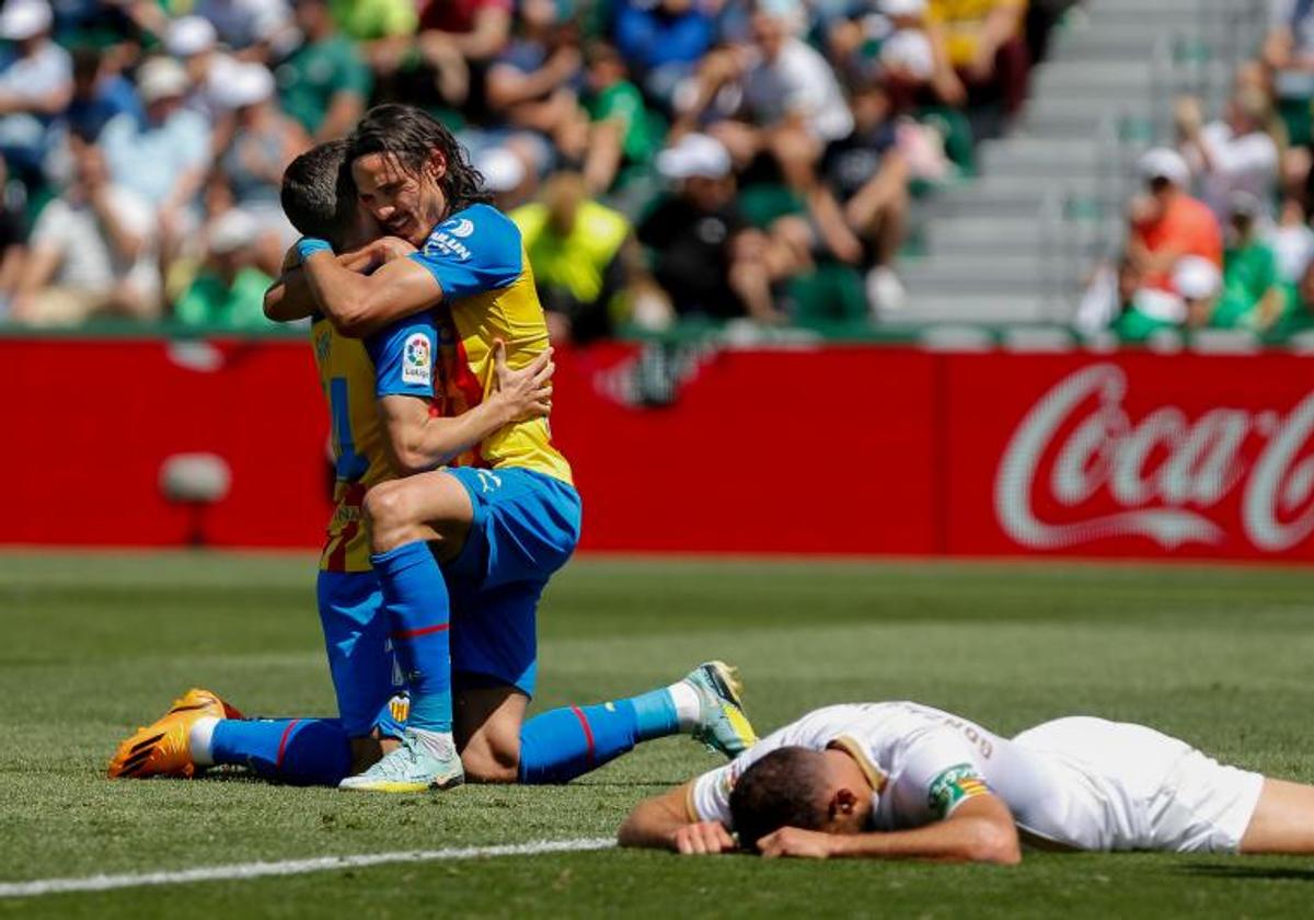 Cavani y Gayà se abrazan ante la desesperación de los jugadores del Elche.