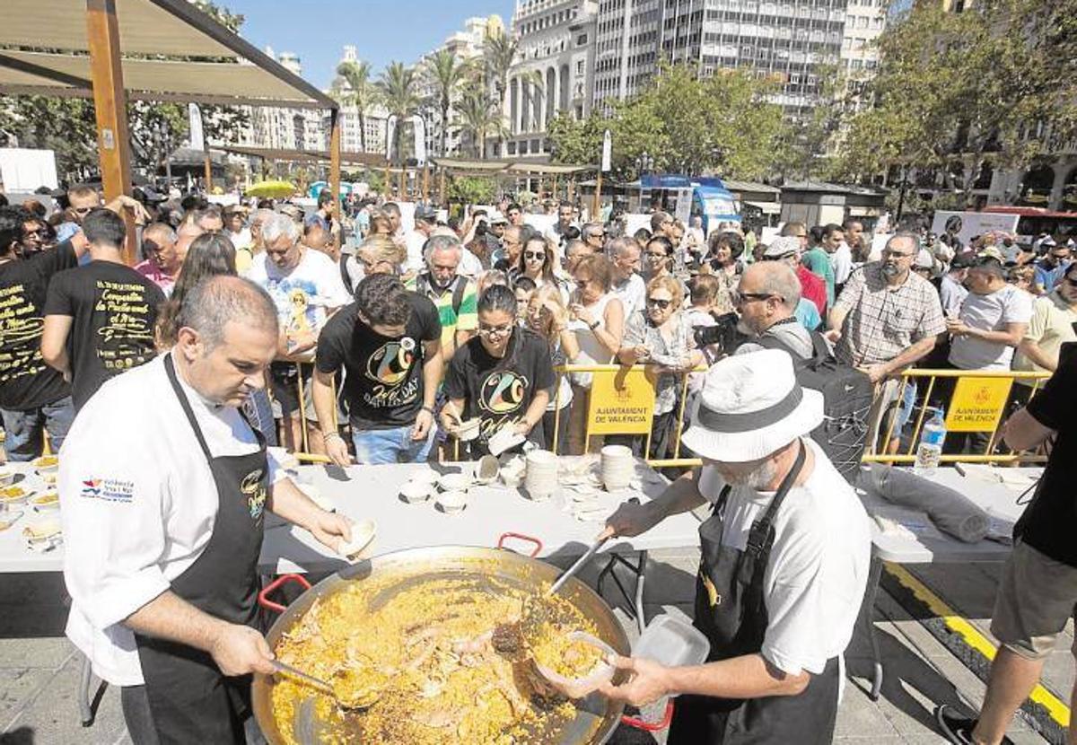 Cocineros reparten raciones de paella en la Plaza del Ayuntamiento