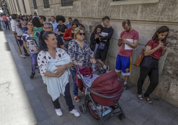 María Teresa Ruiz, con su bebé, en la cola del padrón.