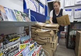 Vicky, con las cajas de Amazon apiladas en su kiosco.