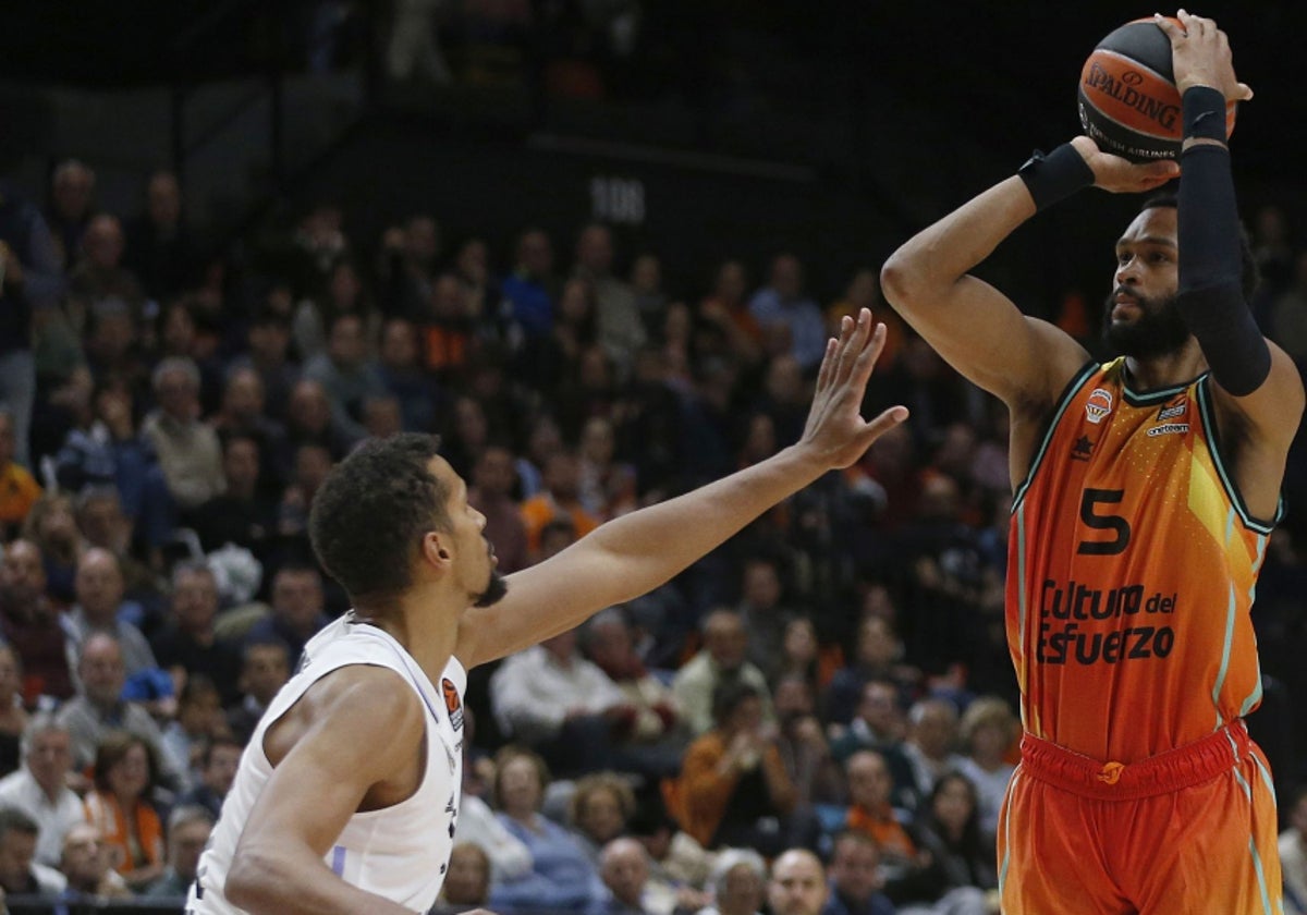 James Web III lanzando a canasta ante un jugador del Real Madrid.