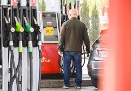 Un hombre repone combustible en su vehículo.