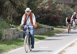 Un mayor circula en bicicleta por el río.