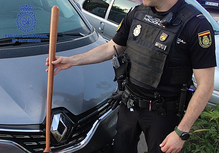 Un policía muestra un bate de béisbol intervenido durante el operativo.