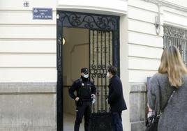 Un policía habla con un hombre en la puerta de la finca donde tuvo lugar el crimen.