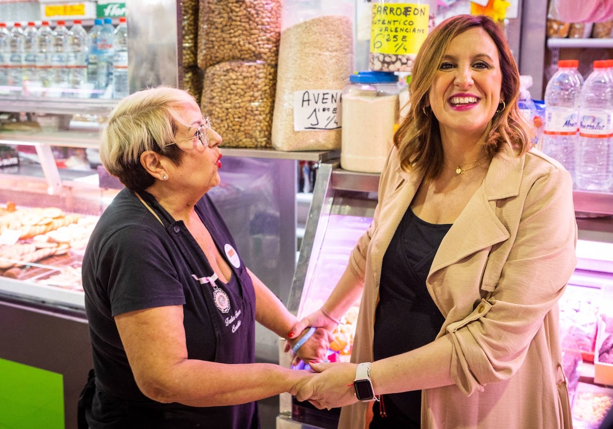 Una vendedora saluda a María José Catalá en el mercado de Ruzafa, este viernes.