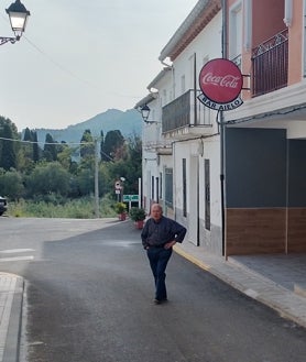 Imagen secundaria 2 - Arriba, el alcalde, en su puesto de trabajo junto a una compañera; en el medio, la plaza del pueblo donde no se ve ningún cartel ni propaganda electoral; sobre estas líneas, uno de los vecinos en la puerta del único bar que hay en el pueblo.