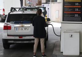 Una conductora reposta en una estación de servicio.