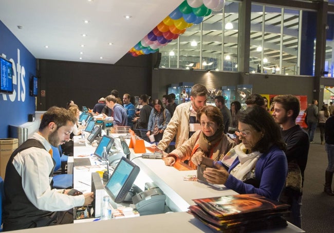 Espectadores adquieren entradas en una sala de cine.