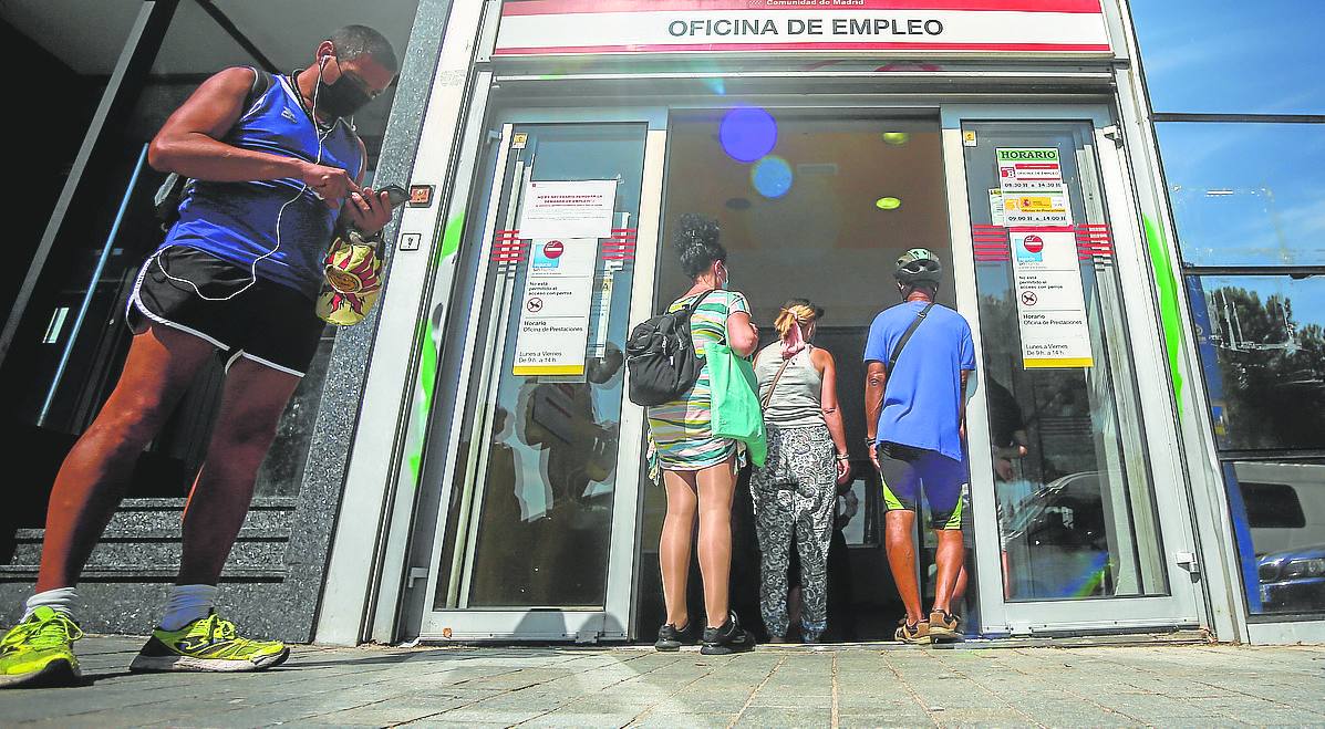 Varias personas haciendo cola frente a una oficina del SEPE.