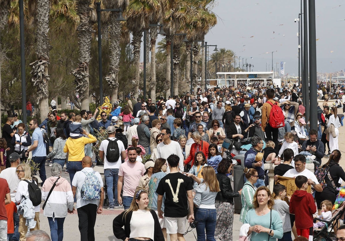 Cientos de personas recorren el paseo marítimo de Valencia.