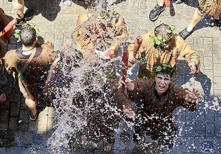 Imagen principal - La 'Degollà' recibida con la tradicional 'poalà' de cubos de agua en las calles Cabillers y Avellanas.