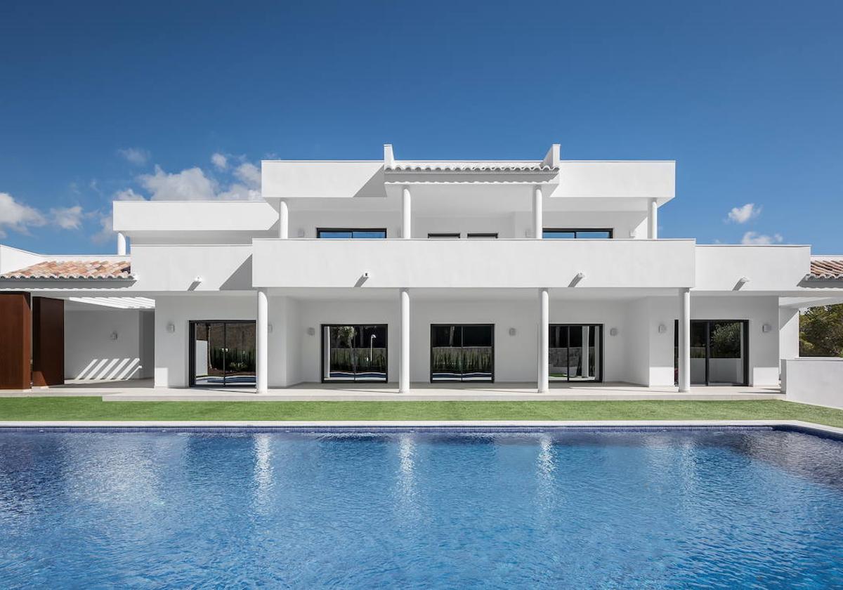 Vista exterior de Villa Moraira, con un gran porche que da a la piscina y abre la vivienda al exterior.