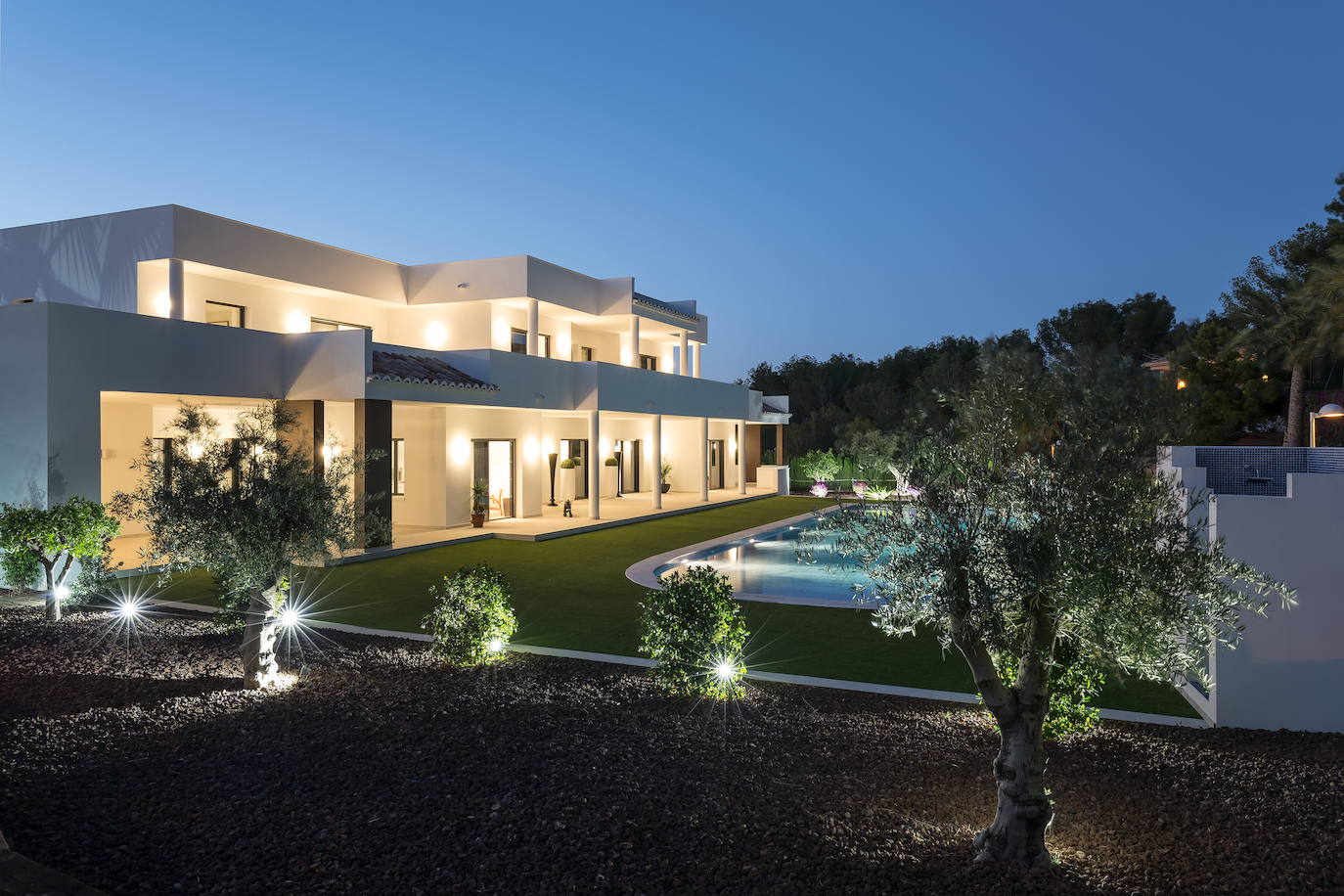 La villa, al atardecer, con sus grandes porches y terrazas superiores.