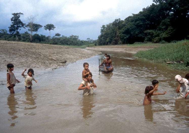 Varios niños, cruzando el río en Araracuara.