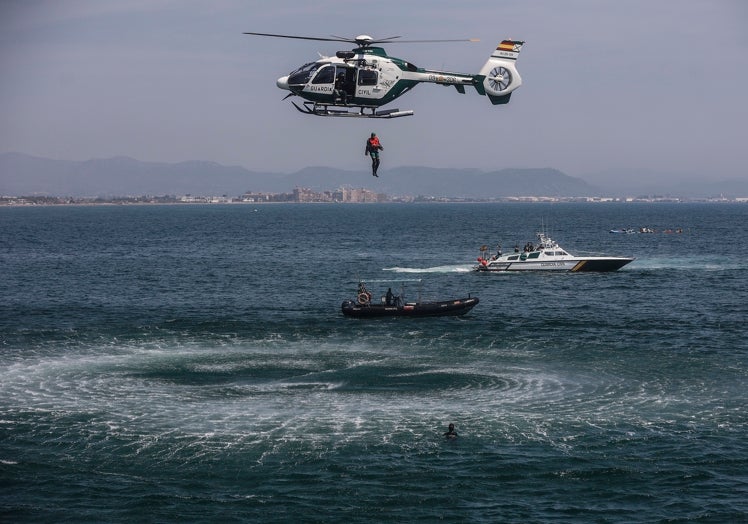 El helicóptero y dos embarcaciones de la Guardia Civil realizan el ejercicio práctico de rescate.