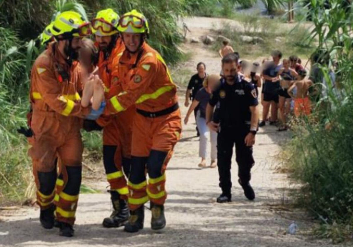 Los bomberos trasladan al menor tras rescatarlo.