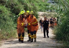 Los bomberos trasladan al menor tras rescatarlo.