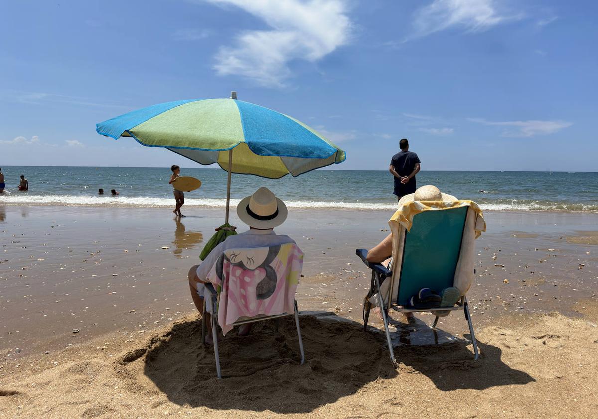 Dos personas disfrutan de vacaciones en la playa, imagen de archivo.