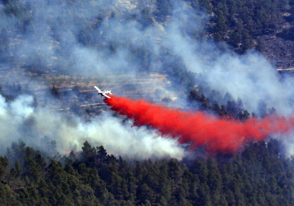 Un avión descarga sobre el terreno afectado por el incendio de Villanueva de Viver.