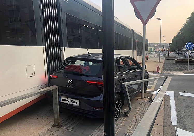 El vehículo, atrapado entre el convoy, la señal y la barandilla.