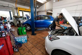 Un mecánico rodeado por coches en un taller del polígono Vara de Quart de Valencia.