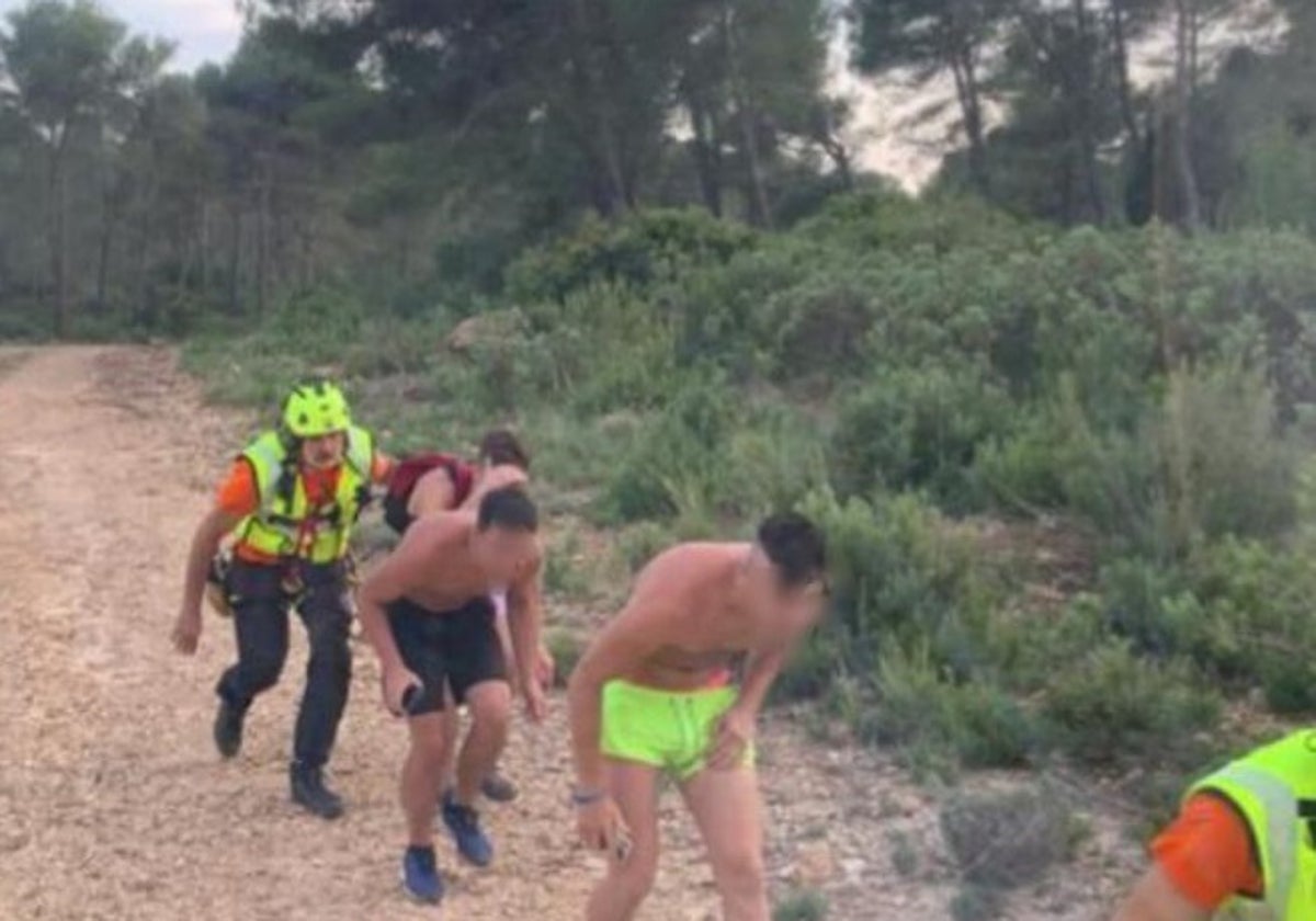 Los tres chicos rescatados antes de subir al helicóptero con los bomberos.