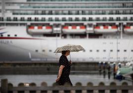 Una mujer se resguarda de la lluvia con un paraguas en una imagen de archivo.