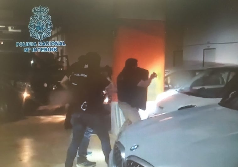 Varios policías detienen al fugitivo en el garaje comunitario.