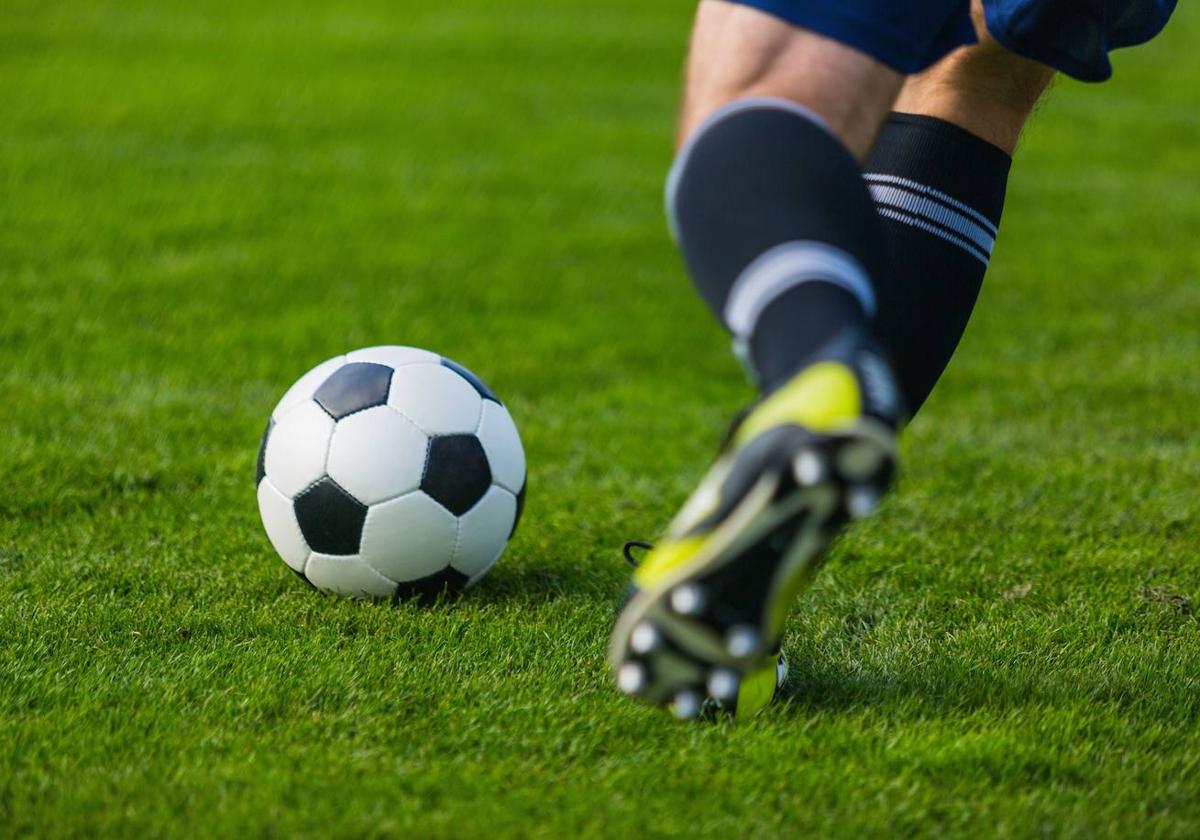 Imagen de archivo de un futbolista golpeando el balón.