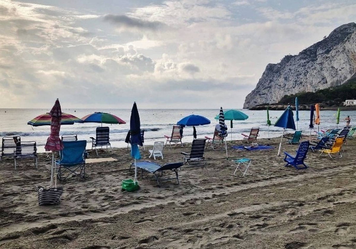 Sombrillas y hamacas vacías en una playa de Calp.