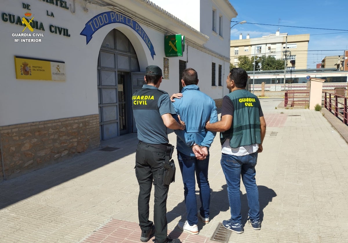 Dos agentes de la Guardia Civil con uno de los detenidos.