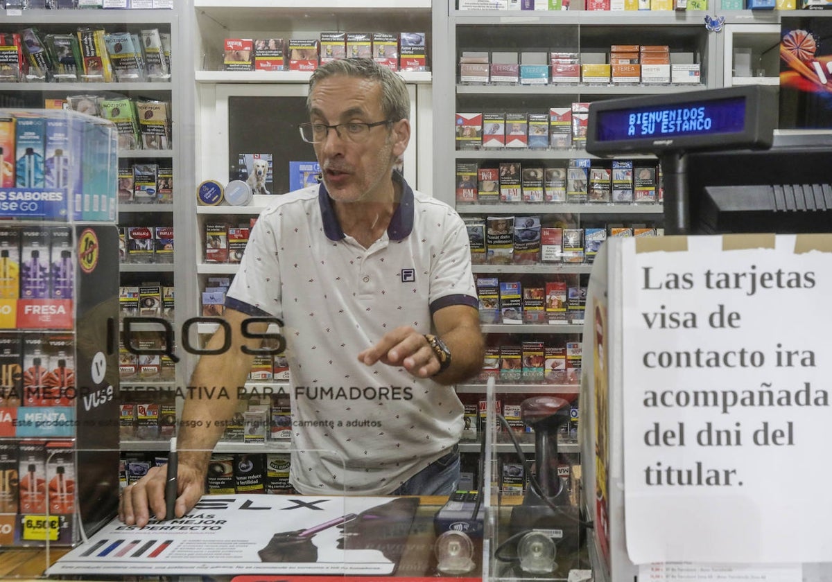 Enrique Fuster, con un cartel donde advierte que no se admiten pagos con tarjeta sin mostrar el DNI.
