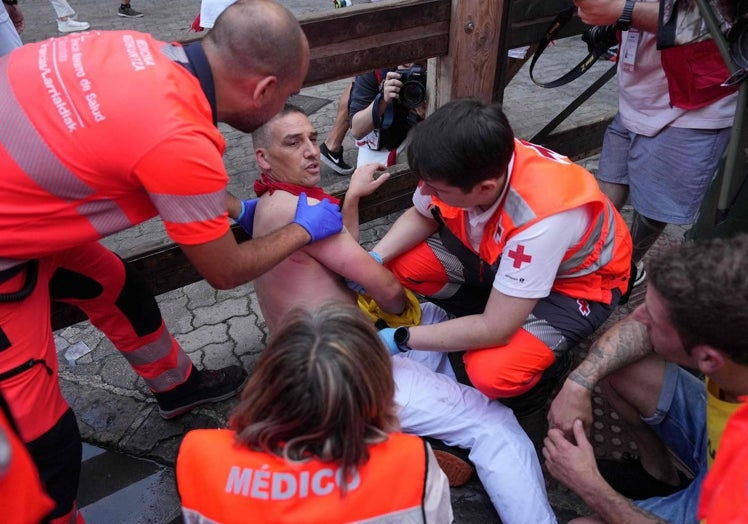 Los servicios médicos atienden a uno de los heridos en el tercer encierro de San Fermín.