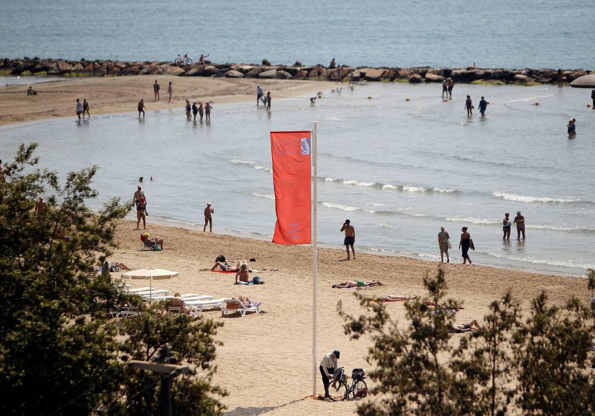 Una playa de Elche ayer con la bandera de prohibido el baño en una imagen de archivo