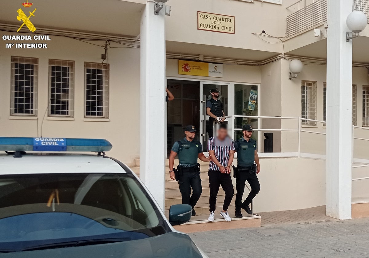 Dos agentes custodian al detenido.