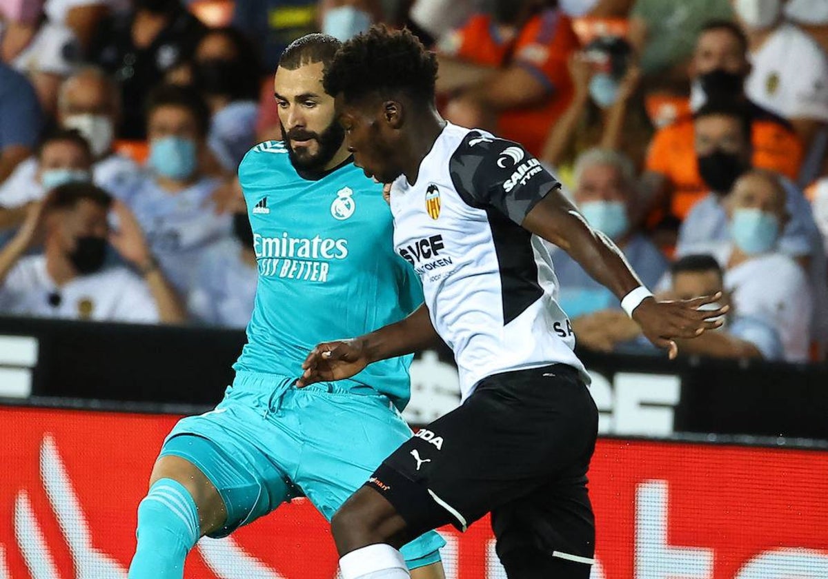 Yunus pelea un balón con Benzema en el partido Valencia-Real Madrid de Mestalla.