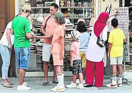 Compra. Familia de turistas buscando souvenirs en una tienda de la ciudad.