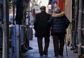 Dos pensionistas pasean por la calle.